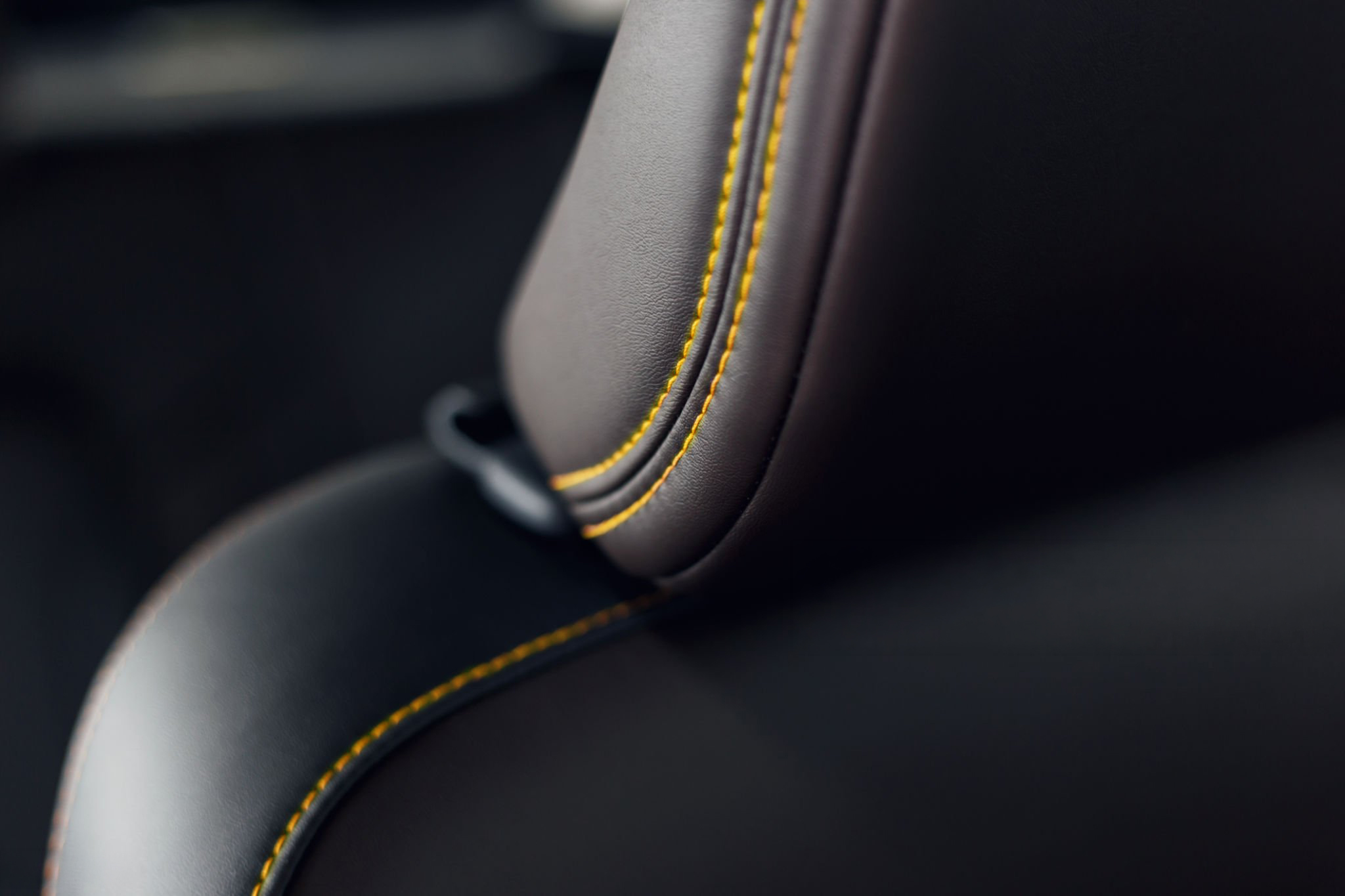 Part of stitched leather black leather car interior. Modern luxury car black perforated leather interior. Car leather interior details